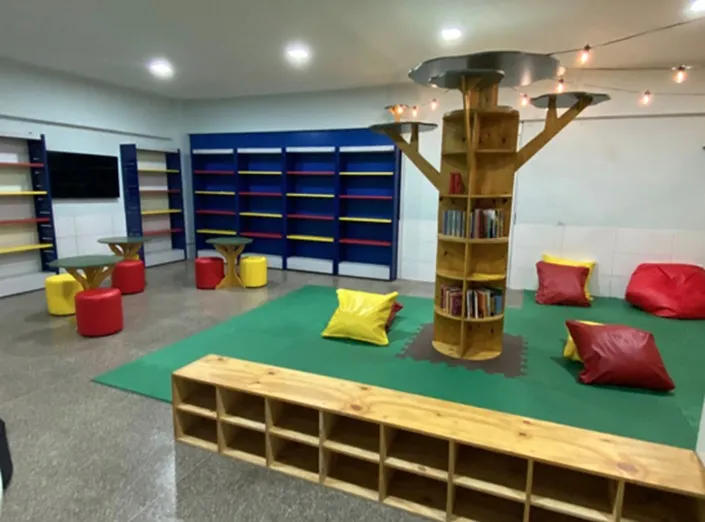 A nova biblioteca utiliza cores em contraste e iluminação mesclada entre difusa e cênica para trazer ao mesmo tempo ambiência aconchegante e estimulante
